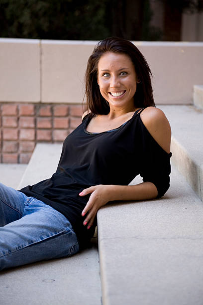 Joven mujer sentada sobre algunos pasos - foto de stock