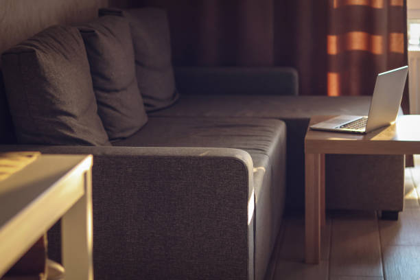 istock Living room in sunset light. Empty sofa and table with laptop. Distant working place. End of the working day. 1468728663