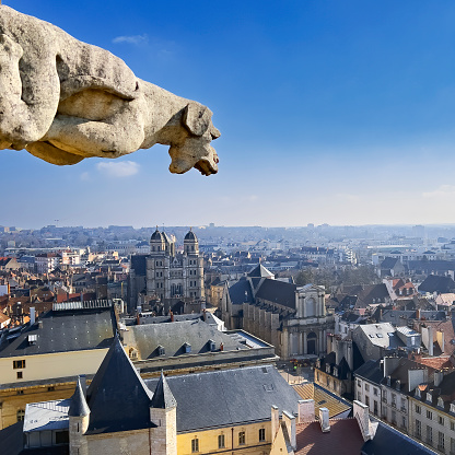Le Stryge Chimera sculpture overlooks Paris from Notre Dame cathedral with Sacre Coeur basilica on the background