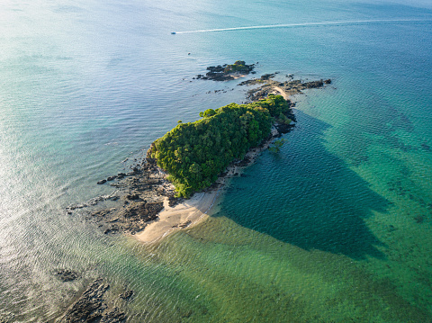 Tiny Beach on a Koh Raeng Island in the Andaman Sea situated near the Island of Koh Lanta in warm light close to sunset. Aerial Drone Point of View towards the small beach and island. Koh Raeng, Ko Lanta, Andaman Sea, Krabi Province, Thailand, Southeast Asia