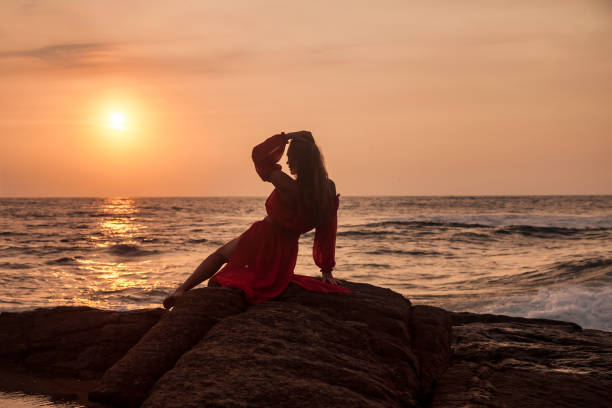 Free Stock Photo of Woman in Red Dress Sitting on Rock by Water ...