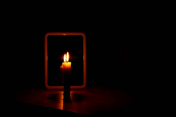 istock candle light in the reflection of a mirror standing on a table in a dark room 1468734123