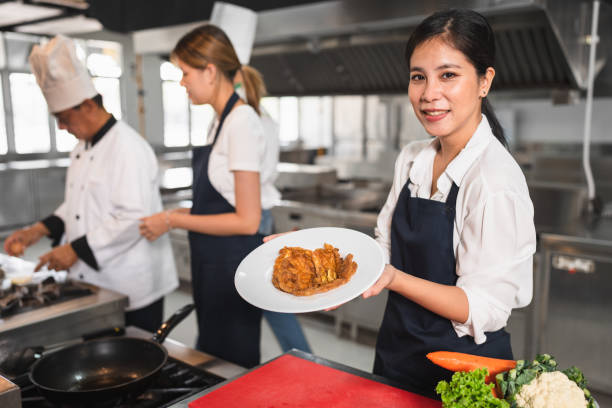 istock Happy student Asia woman assistant chef holding omelet with kitchen background 1468739208