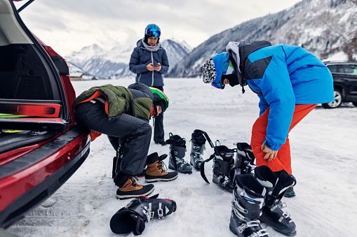 Mother and three teenage kids are preparing for a day of skiing in Austrian Alps. They are wearing the ski boots.
Canon R5