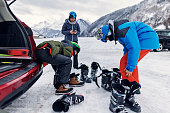 Family putting on ski gear before skiing in European Alps