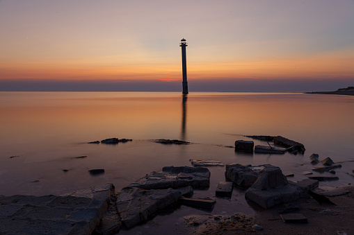 Kiipsaare lighthouse in Saaremaa, Estonia. Iconic local landmark - skew abandoned lighthouse. Sunset with a red colored sky.