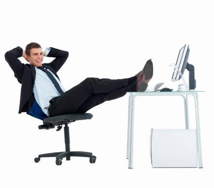 Happy businessman relaxing at office desk against white background
