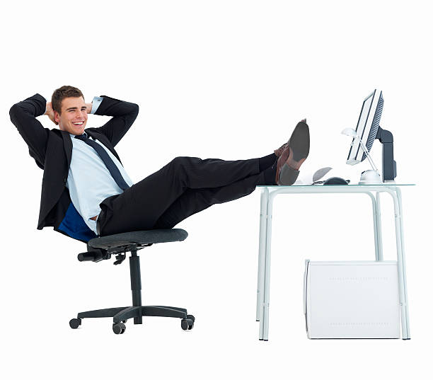 счастливый бизнесмен расслабляющий на офисный стол на белом фоне - looking at camera smiling desk isolated стоковые фото и изображения