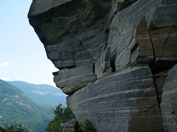 Scenic view from lower trail in Chimney Rock State Park, North Carolina. View includes a unique rock formation, and looks towards the lush green Lake Lure valley. Image is part of Chimney Rock series and was created on a DSLR camera with low ISO in daylight. Copy Space is available in the upper left corner in the sky area. Several well-known movies have been filmed in this location in Rutherford County.
