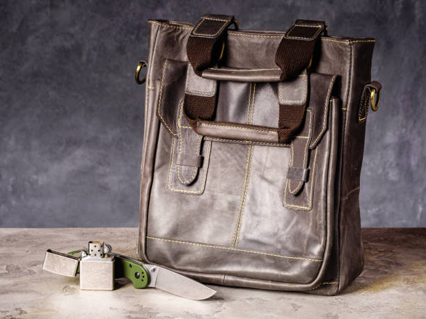 istock Green folding EDC knife and vintage lighter near a leather bag 1468745210