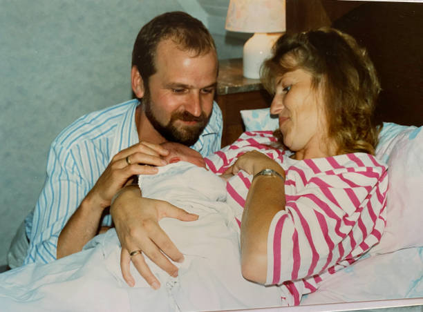Young father and mother back in time Happy young father and mother holding the new born baby, back in time father daughter 80s stock pictures, royalty-free photos & images