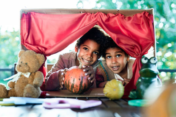 istock Happy black kids having a puppet show on a terrace. 1468746351