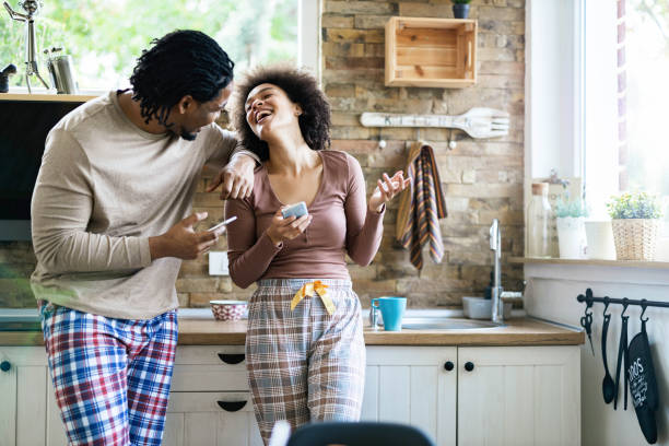 istock Cheerful black couple talking while using cell phones in the morning. 1468746409