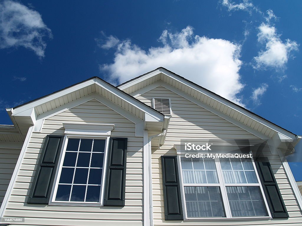 Suburban Home Closeup of Suburban Home with bright blue sky and white clouds Window Stock Photo