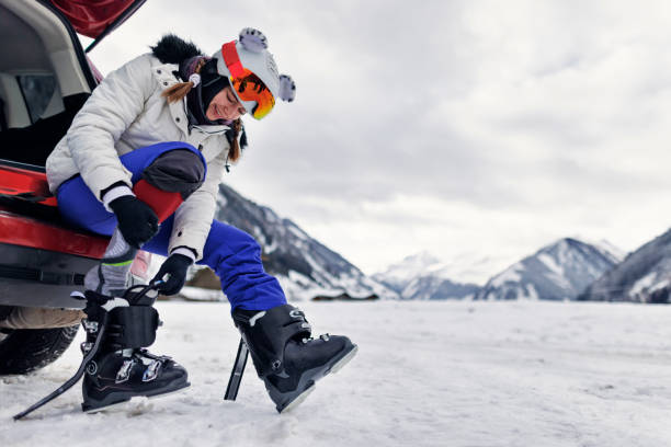 adolescente colocando em equipamento de esqui antes de esquiar nos alpes europeus - skiing snow skiing helmet fun - fotografias e filmes do acervo