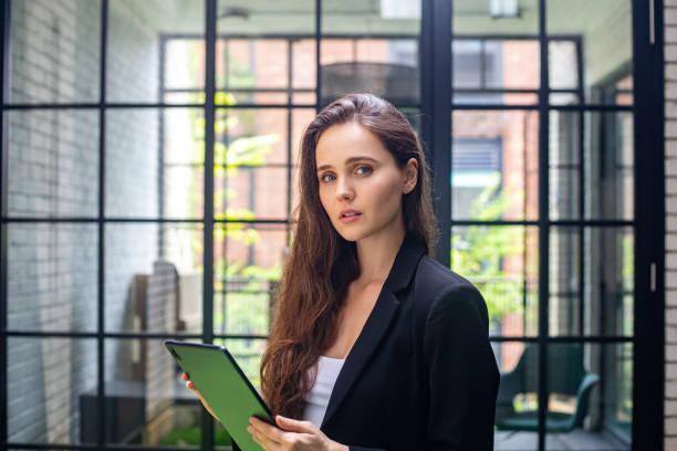 istock Confident business woman using digital tablet looking at camera. 1468750034