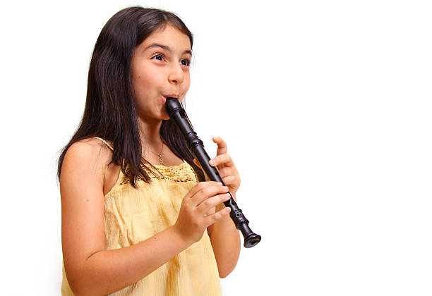 child playing flute according to notes. learning to play musical instruments at music school.