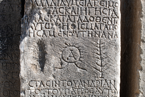 Piran, Slovenia - September 18 2022. A tombstone in the surrounding wall of the historic St George's Parish Church in the medieval centre of Piran on the coast of Slovenia. Called Zupnijska Cerkev Sv Jurija in Slovenian, this Renaissance Roman Catholic church dates from the 16th century