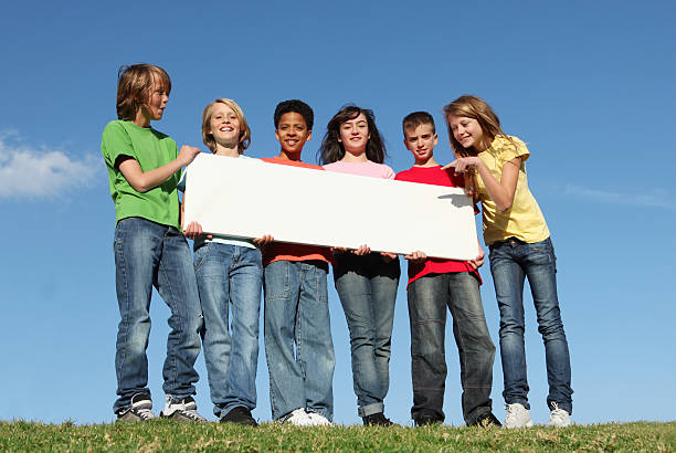 Six diverse kids holding a blank white sign stock photo