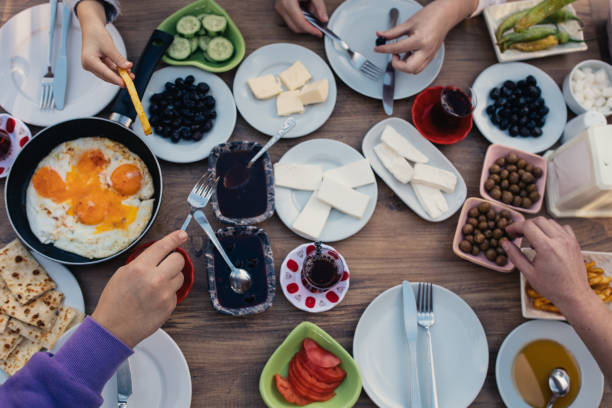 istock Turkish breakfast with people's hands reaching for the dishes top view. 1468756411