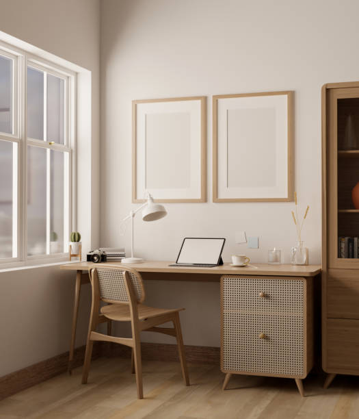 Cozy minimal home workspace with tablet mockup on wood table, frames on white wall. stock photo