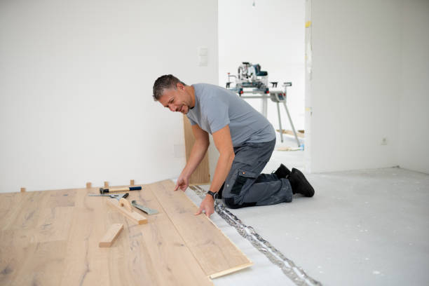 Middle aged man with grey hair and grey shirt laying parquet floor Middle aged man with grey hair and grey shirt laying parquet floor in new loft, house floor length stock pictures, royalty-free photos & images