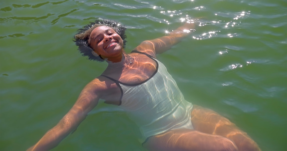 Portrait of smiling young woman swimming in lake.
