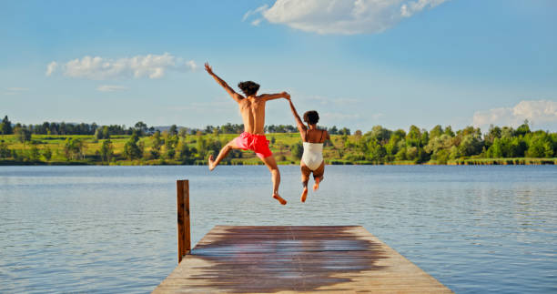 istock Young couple jumping in lake 1468763872