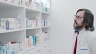 istock Male pharmacist attentively looks for medicine at the shelves 1468763920