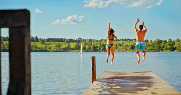 istock Young couple jumping in lake 1468763968