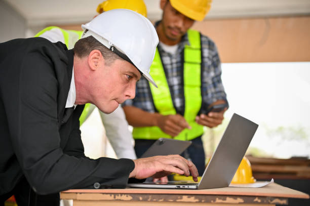 istock Caucasian businessman using a laptop while working with a team of construction engineers 1468767788