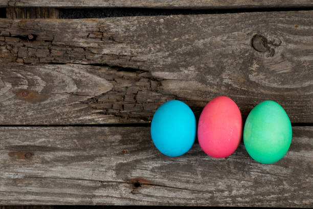 istock Easter dinner, colored chicken eggs on an old wooden table in the evening on Easter day. 1468768432