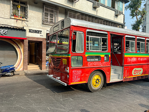 Passengers on one of the iconic red and yellow passenger busses that has been a feature for decades of the city of Mumbai, India