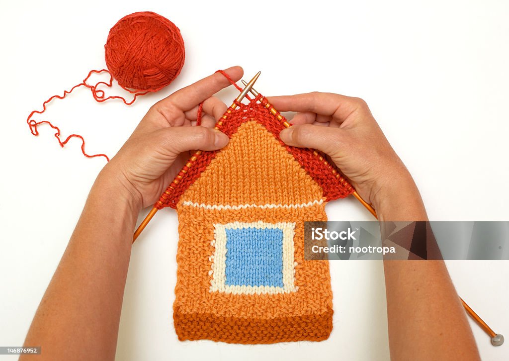 A red and orange knitted house Knitted house on white background House Stock Photo