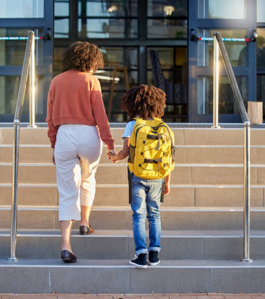 istock Mother, child and holding hands at school building, education with backpack and ready to learn at academy. Learning, study and student, black woman support kid for first day back to school. 1468769899