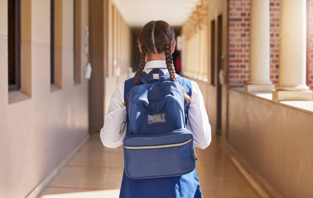 istock Girl student, backpack and walking in a school back for study, education and morning class. Young students back view walk in a hall about to learn and study on campus for youth knowledge development 1468769925