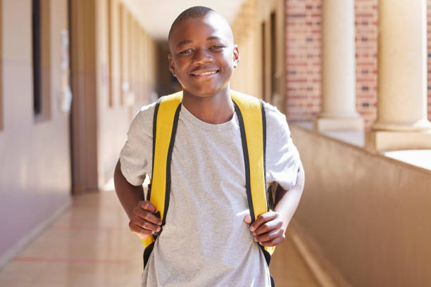 istock Student, child and backpack standing in school campus lobby for study. Back to school portrait, African boy and ready for education, learning or knowledge with happy smile in high school building 1468770377