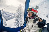 Cool teenage boy enjoying gondola ski lift ride in Alps