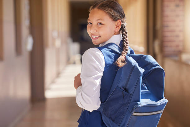 istock Education, backpack and learning with a school girl walking down a corridor to class to study for development. Children, student and portrait with a female kid in an academic building for knowledge 1468774606
