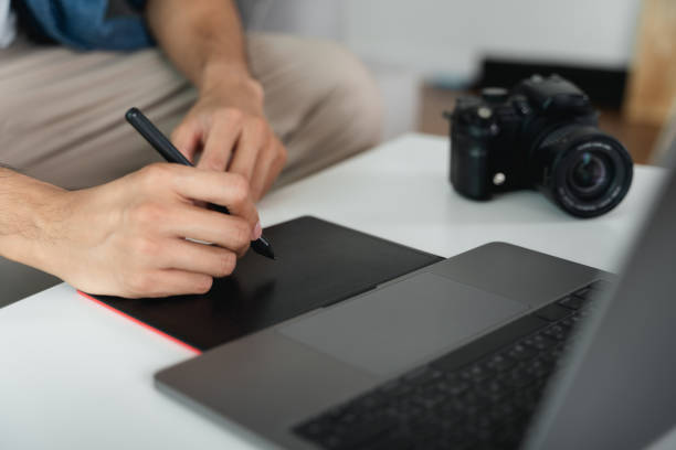 istock Man Designer using pen mouse tablet drawing and writing on tablet board with stylus for retouching, and graphic design. 1468775418