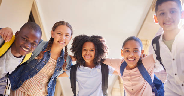 istock School, circle and children portrait for group support, learning and education with diversity friends outdoor. Happy, back to school and knowledge of students or kids with backpack hug together 1468776408