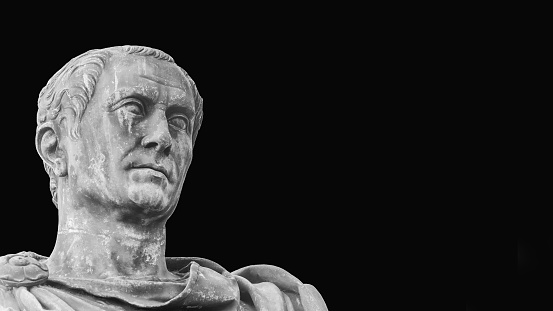 Julius Caesar, the most famous general and leader of Ancient Rome. An old bronze statue replica along Imperial Fora Rome in Rome
