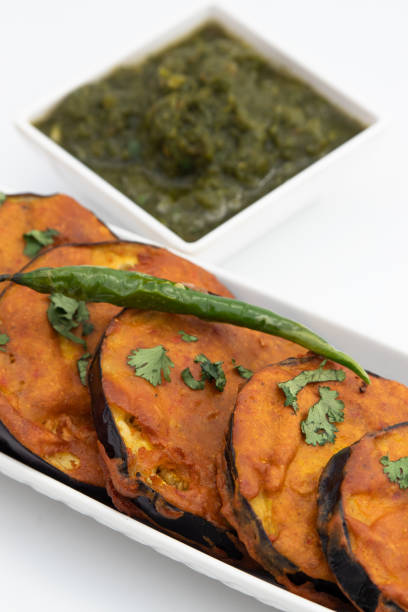 Bengali Eggplant Pakoda Called Begun Bhaja, Baingan Tawa Fry Prepared From Slices Of Brinjal Marinated With Gram Chickpea Flour, Hot Spices Garam Masala. Enjoyed On Holi, Navaratra, Durga Puja, Diwali la berenjena bengalí pakoda llamada bhaja comenzada, alevines de baingan tawa preparados a partir de rodajas de berenjena marinada con harina de garbanzos gram, especias picantes garam masala. disfrutado en holi, navaratra, durga puja, diwali