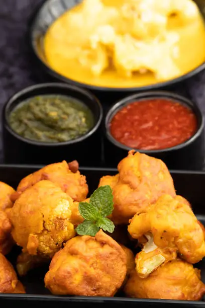 Photo of Gobi Pakoda Also Called Gobhi Pakora, Pakodi, Fakkura, Bhajiya, Bhajji, Bhaji, Ponako, Bajji Are Tea Time Indian Snacks Made Of Cauliflower Florets Marinated Tossed In Gram Flour Batter, Garam Masala