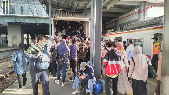 electric train passengers crammed onto the platform after exiting the electric train car. this is the usual view at the Tangerang station, Indonesia, 24 October 2022