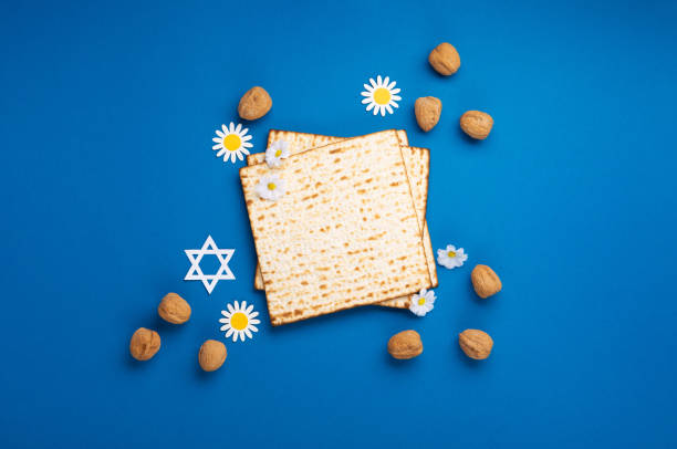 istock Passover Greeting Card with Matzah, Nuts and Spring Flowers on Blue Background. 1468782536