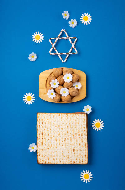 istock Passover Greeting Card with Matzah, Nuts and Spring Flowers on Blue Background. 1468782556