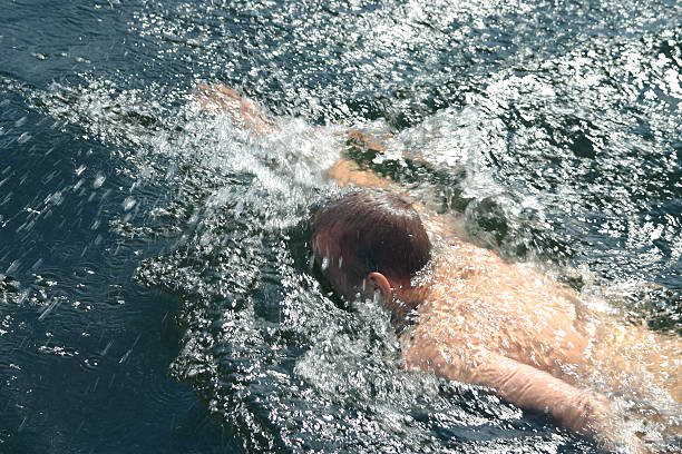 Menino Nadando no lago - fotografia de stock