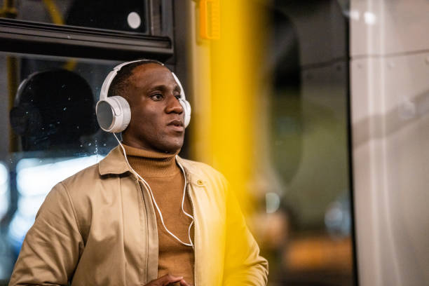 istock Young man in headphones riding bus at night 1468787529