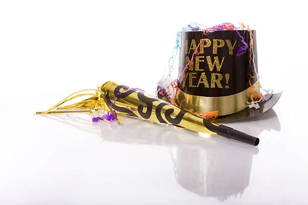 Party favors including top hat that says Happy New Year  and horn isolated against white background